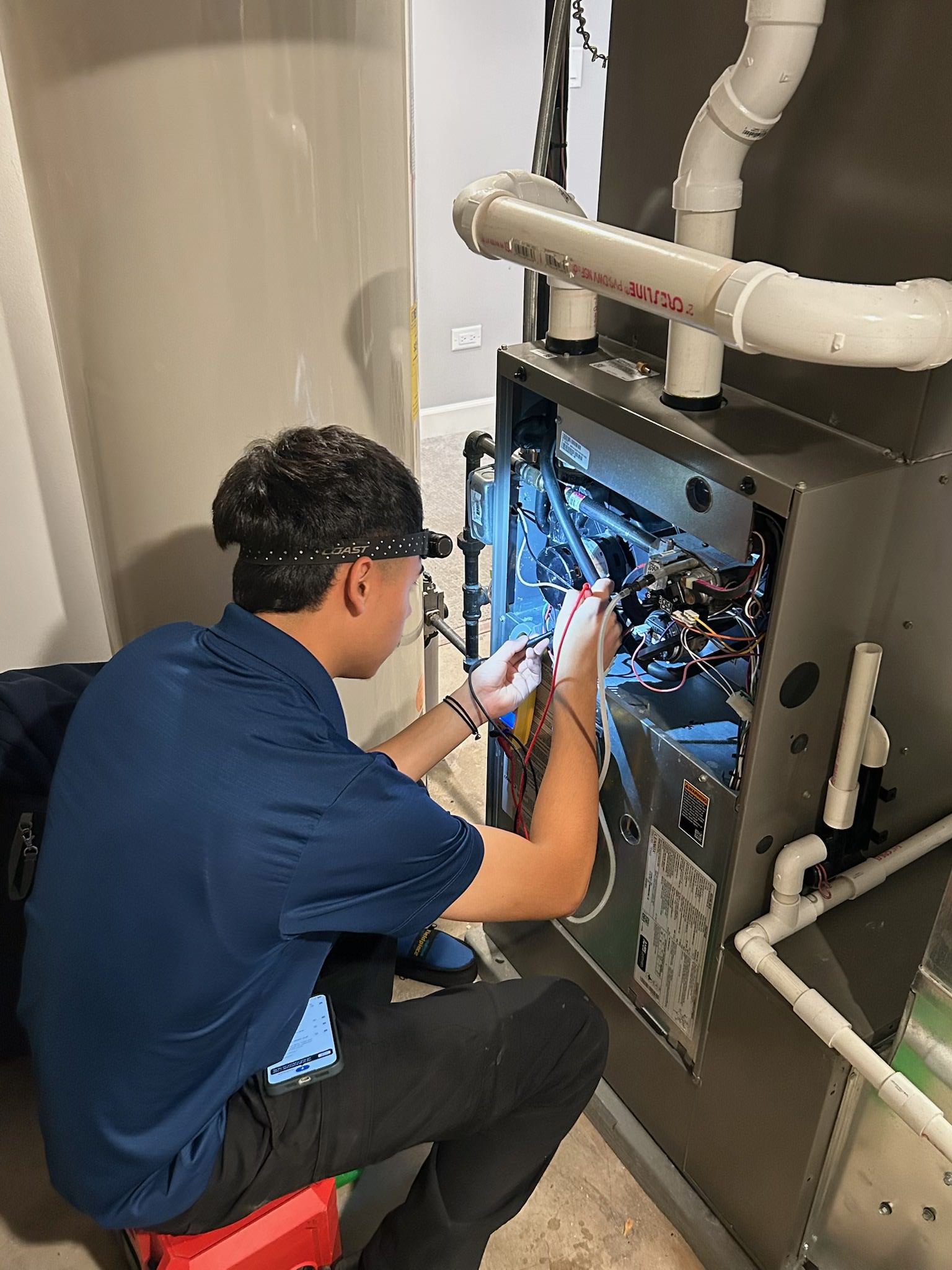 A Ragano Heating & A/C Inc. technician repairing a furnace in Bartlett